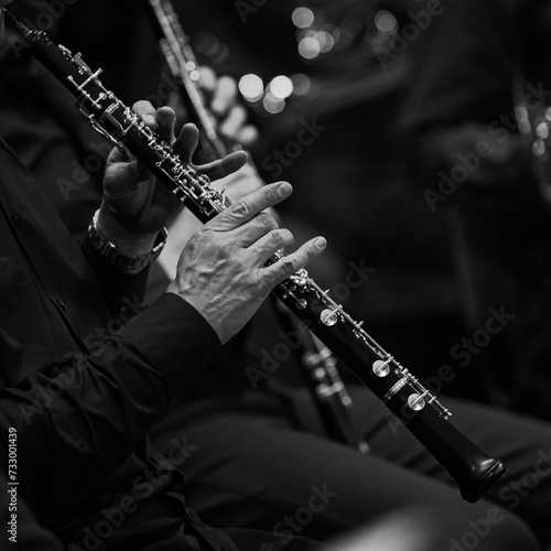 Hands of a musician playing the oboe in an orchestra in black and white