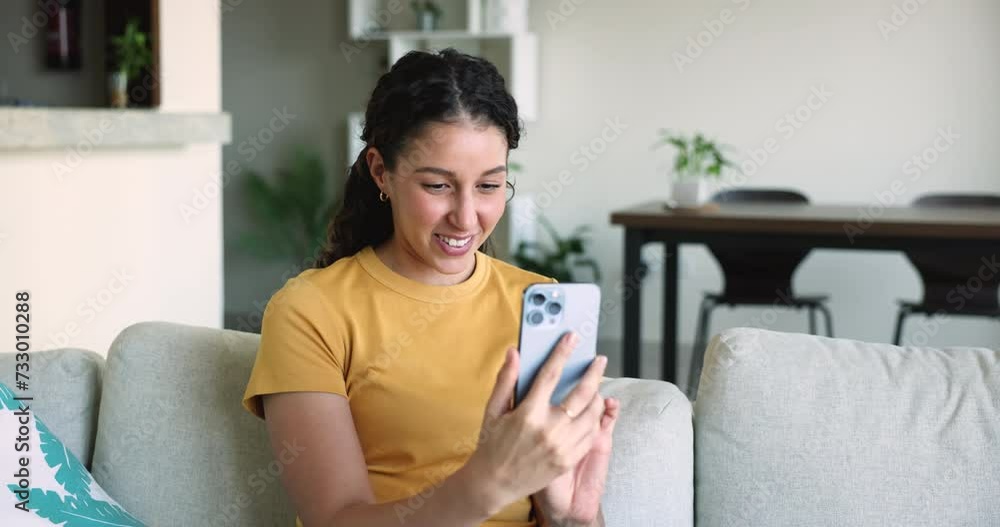 Young Latina woman using smart phone, enjoy on-line chat, laugh, share messages or sms communicates with friends via social media network or messenger application spend free time on internet at home Young Latina woman using smart phone, enjoy on-line chat, laugh, share messages or sms communicates with friends via social media network or messenger application spend free time on internet at home