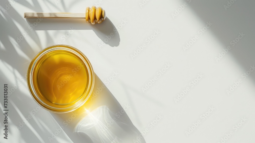 Glass jar full of honey and wooden stick on a white background.