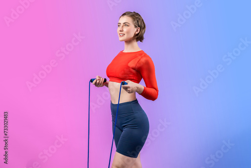 Full body length gaiety shot athletic and sporty young woman with fitness skipping rope in standing posture on isolated background. Healthy active and body care lifestyle.