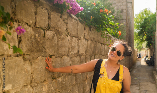 woman with sunglasses and a yellow dress smiling in the summer hollidays photo