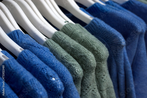 closeup of colorful woolen pullover on hangers in a woman fashion store showroom