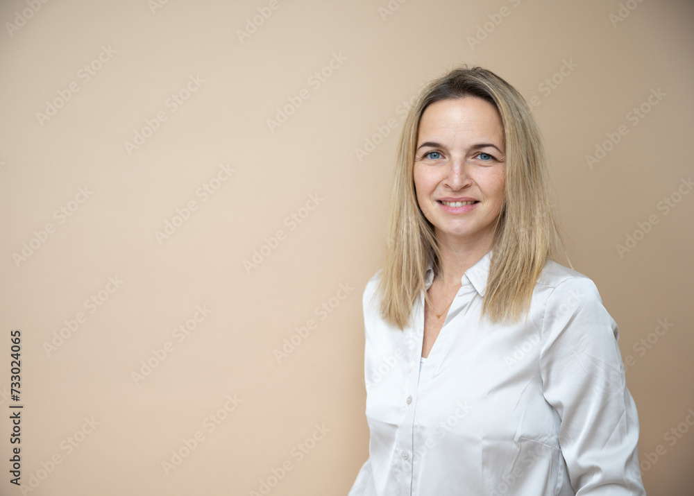 Fototapeta premium beautiful mid age business woman posing in front of brown background