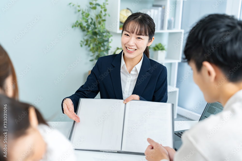 室内で家族にファイルを見せる女性 室内で家族にファイルを見せる女性