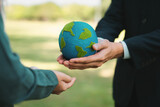 Earth day concept, businessman giving Earth globe to colleague as CSR corporate social responsible principle to promote environmental awareness and embrace ESG for greener and sustainable future. Gyre