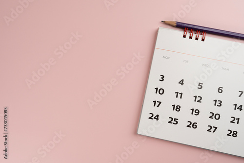 close up of calendar and pencil on the pink table background, planning for business meeting or travel planning concept