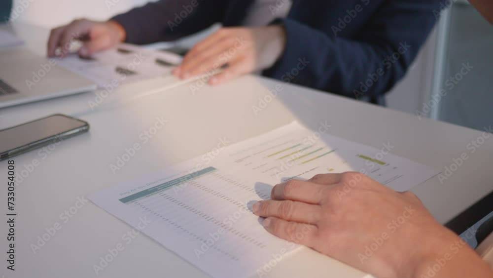 Company employee holding paper with statistics data in hands and collaborating with team close up. Report analysis and teamwork in office meeting concept Company employee holding paper with statistics data in hands and collaborating with team close up. Report analysis and teamwork in office meeting concept