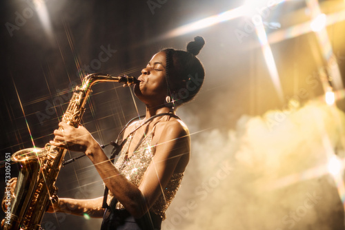 Canvas Print Portrait of talented Black young woman playing saxophone performing jazz music a