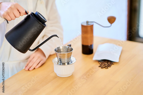 キッチンでコーヒーを淹れる若い女性