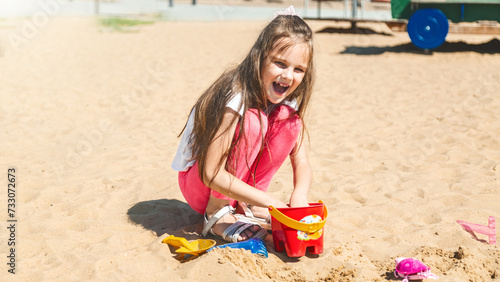 cute caucasian child playing in sandbox with plastic colorful toys at playground © Mariia