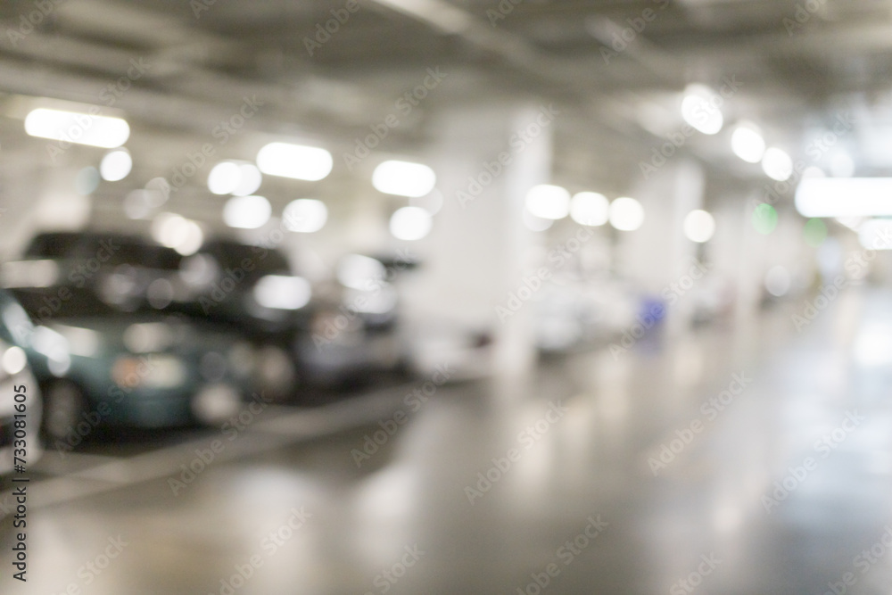 Obraz premium Blurred image of many cars parked in the parking lot under the building to go shopping in the mall which has a good care of safety bright parking There is a CCTV box recording.