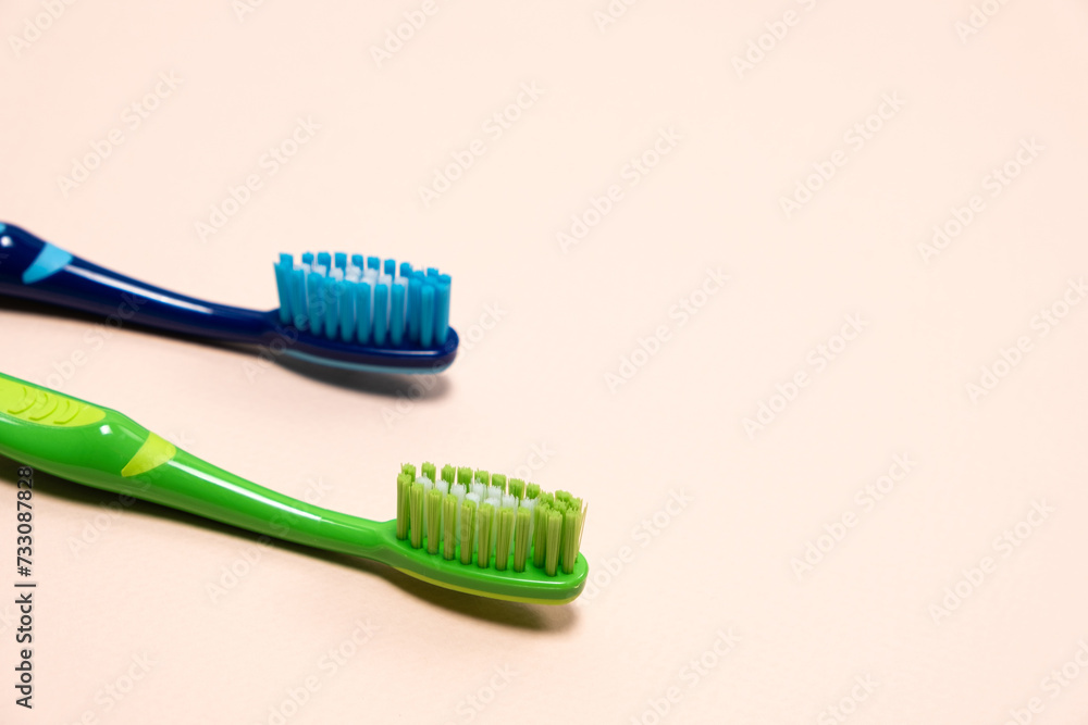 Two toothbrushes on a beige background, copy space for text. Two toothbrushes on a beige background, copy space for text.