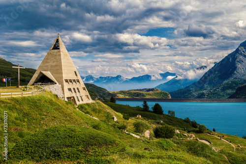 Pyramid shaped church and lake Mont-Cenis among mountains in France. photo