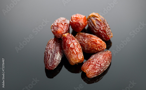 Dates fruit. Date fruits on black background. Heap of Medjool dates close up. Tasty healthy Food close up