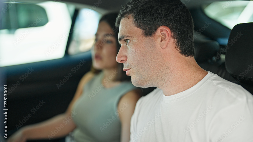 Beautiful couple passengers sitting on car at street Beautiful couple passengers sitting on car at street
