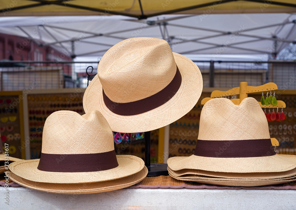 Classic men's beige and brown straw hats at an outdoor market