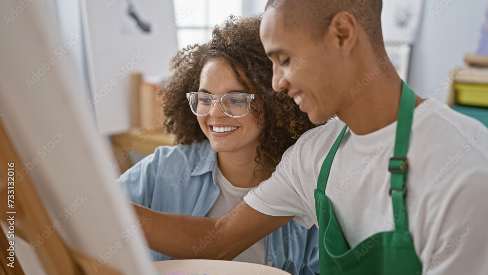 Confident man and woman artists, joyfully smiling and drawing together in a vibrant art studio Confident man and woman artists, joyfully smiling and drawing together in a vibrant art studio