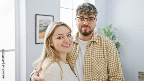 A loving couple embraces in a bright modern living room, exuding happiness and comfort. © Krakenimages.com