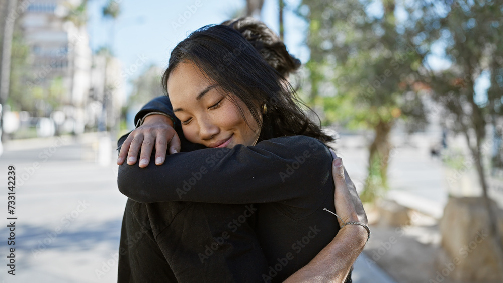 Interracial couple embracing on a city street, exuding joy and love in an urban outdoor setting Interracial couple embracing on a city street, exuding joy and love in an urban outdoor setting