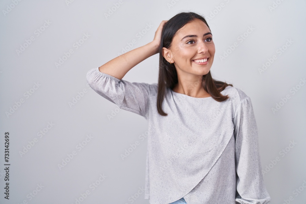 Young hispanic woman standing over white background smiling confident touching hair with hand up gesture, posing attractive and fashionable Young hispanic woman standing over white background smiling confident touching hair with hand up gesture, posing attractive and fashionable
