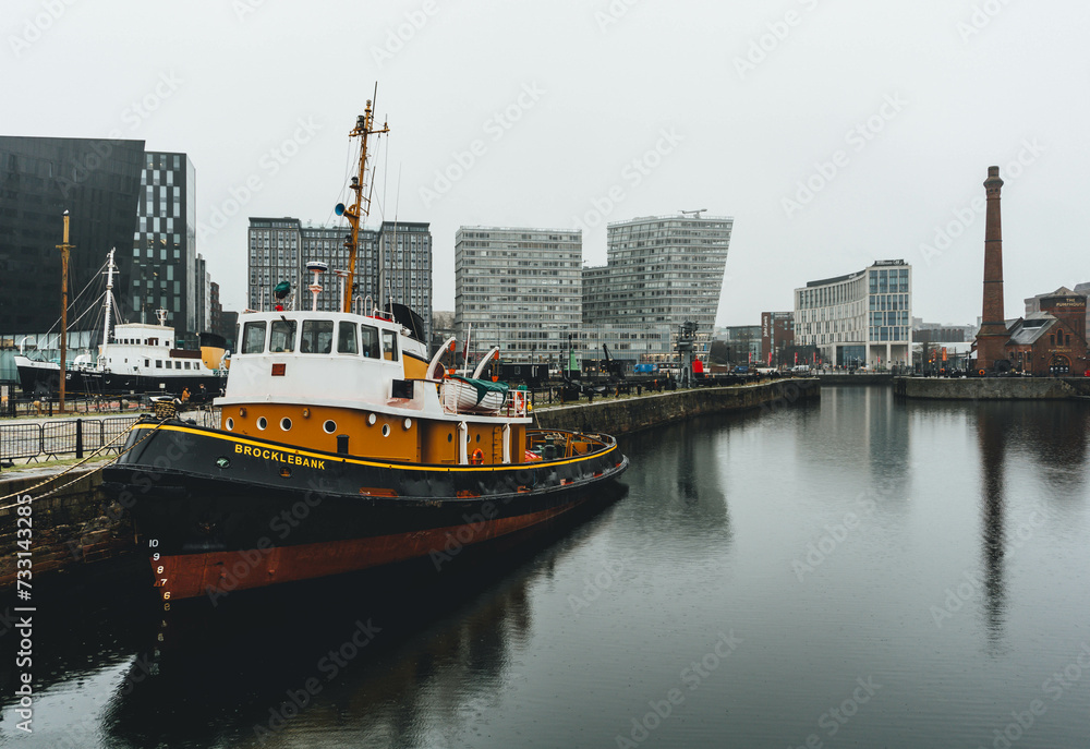 view of modern museum building with big yellow boat reflected on cold waters of docks