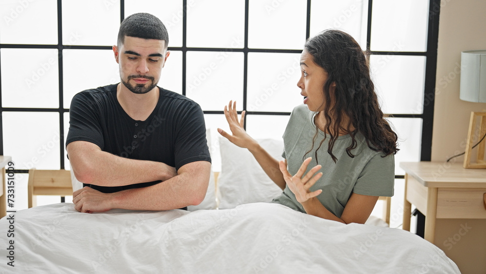 Beautiful couple arguing in bedroom, a serious disagreement amidst a lovely morning, stressed expression on their faces as they sit on bed in their home, a problem pulling them apart Beautiful couple arguing in bedroom, a serious disagreement amidst a lovely morning, stressed expression on their faces as they sit on bed in their home, a problem pulling them apart