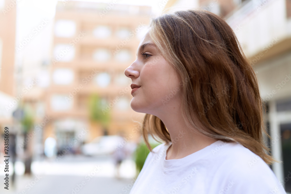 Young caucasian woman looking to the side with serious expression at street Young caucasian woman looking to the side with serious expression at street
