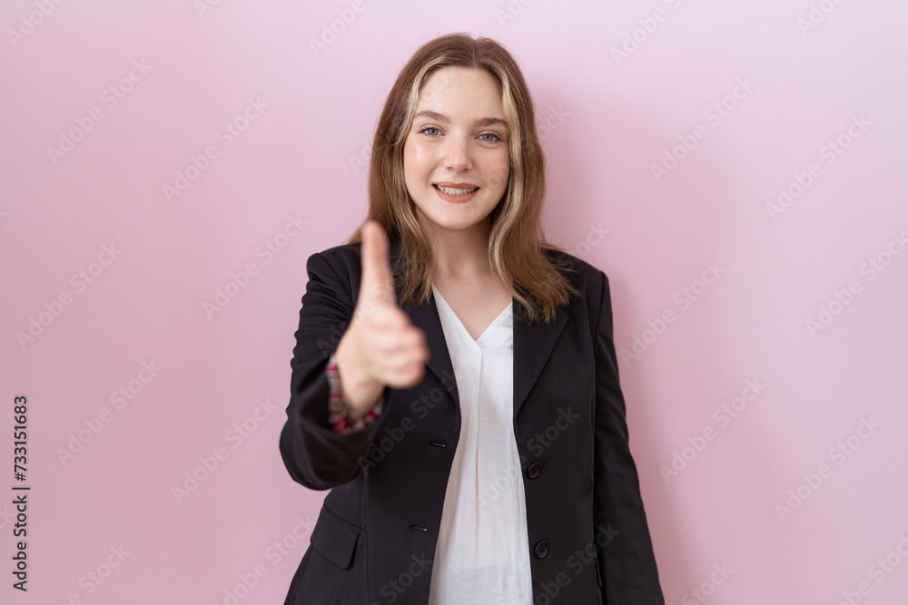 Young caucasian business woman wearing black jacket smiling friendly offering handshake as greeting and welcoming. successful business. Young caucasian business woman wearing black jacket smiling friendly offering handshake as greeting and welcoming. successful business.