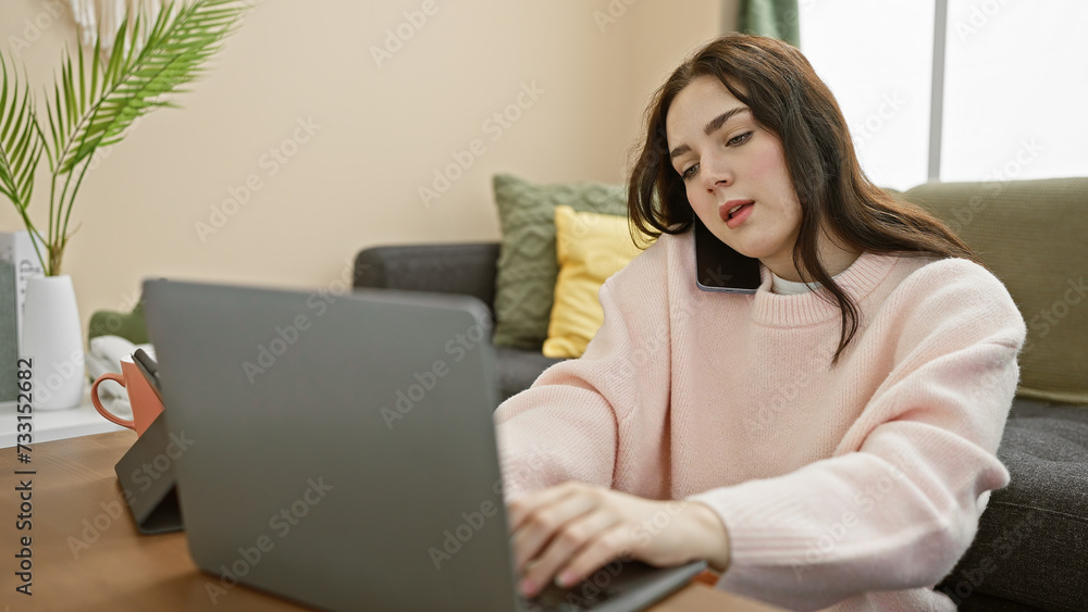A young woman multitasks using a smartphone and laptop in a cozy home interior, depicting modern remote work. A young woman multitasks using a smartphone and laptop in a cozy home interior, depicting modern remote work.
