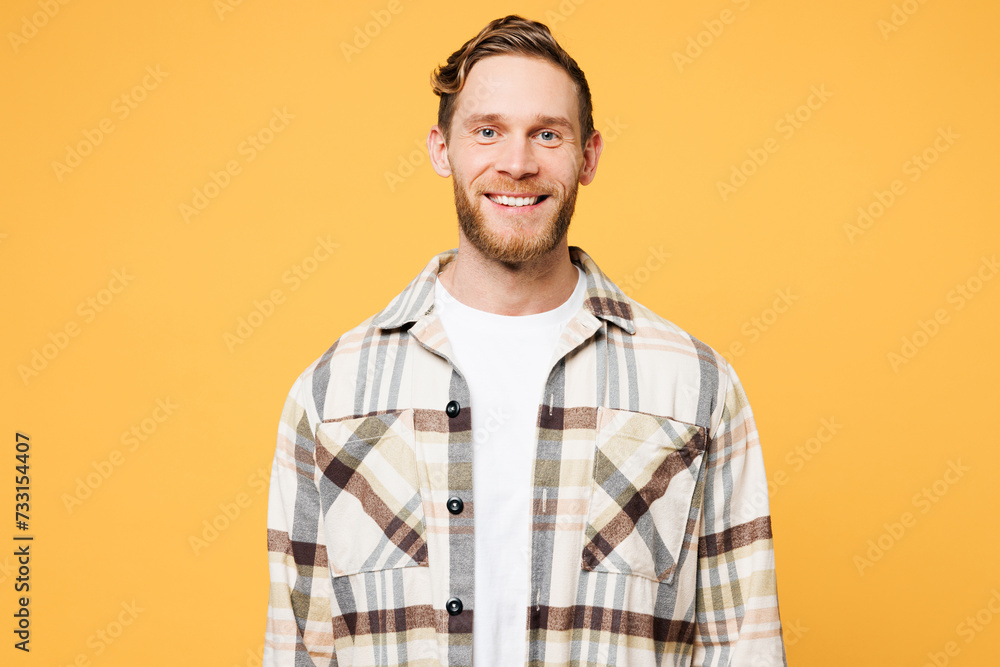 Young smiling satisfied happy cheerful positive Caucasian man he wearing brown shirt casual clothes looking camera isolated on plain yellow orange color background studio portrait. Lifestyle concept. Young smiling satisfied happy cheerful positive Caucasian man he wearing brown shirt casual clothes looking camera isolated on plain yellow orange color background studio portrait. Lifestyle concept.