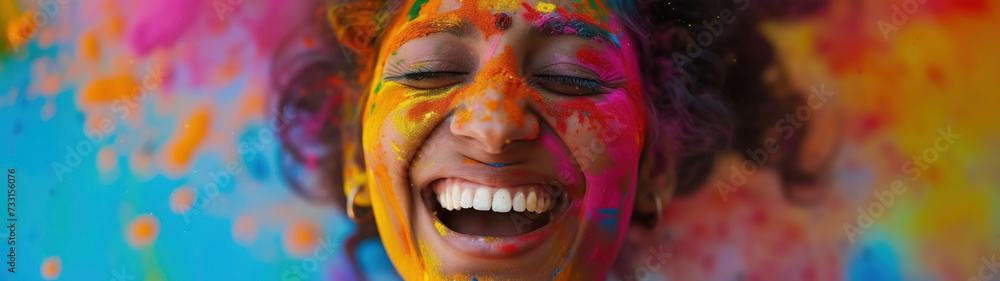 An Indian woman laughing joyfully with her face covered in vibrant colored powder. Holi Festival, India's Most Colorful Festival