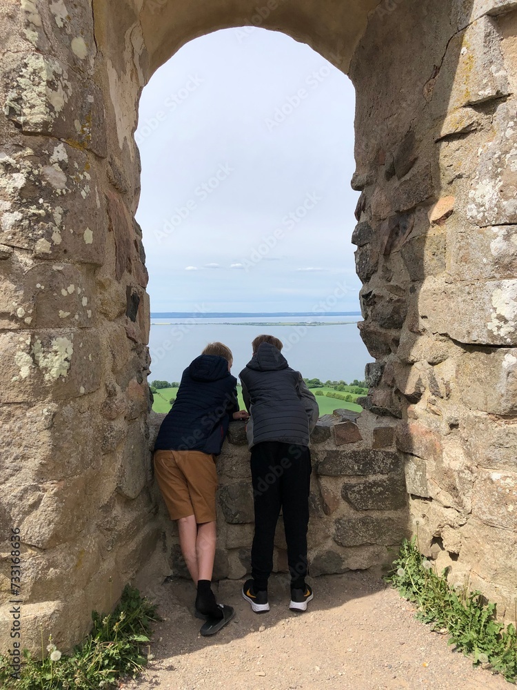 couple looking at the sea in the window in the old ruin