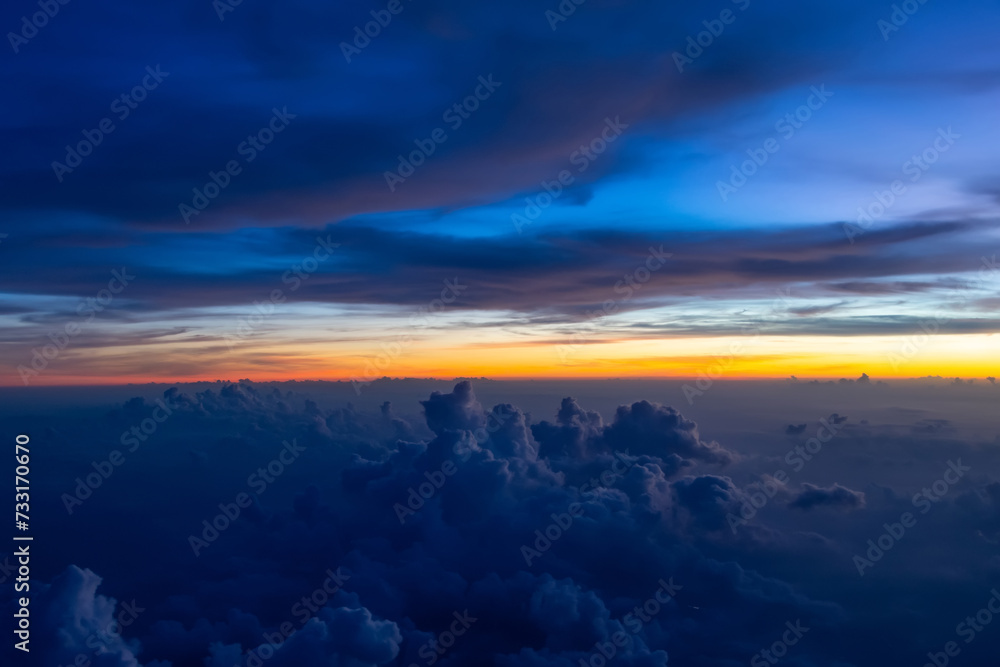 Dark heavy thunderstorm cumulus clouds in the morning at dawn, cloudscape view from an airplane