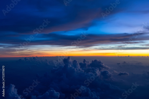 Dark heavy thunderstorm cumulus clouds in the morning at dawn, cloudscape view from an airplane