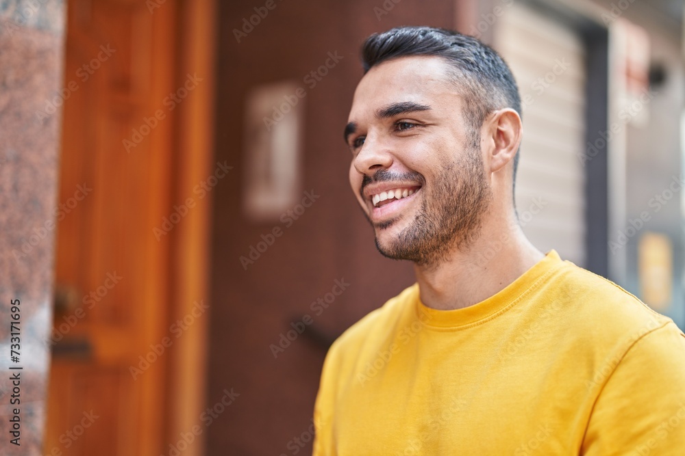 Young hispanic man smiling confident looking to the side at street Young hispanic man smiling confident looking to the side at street