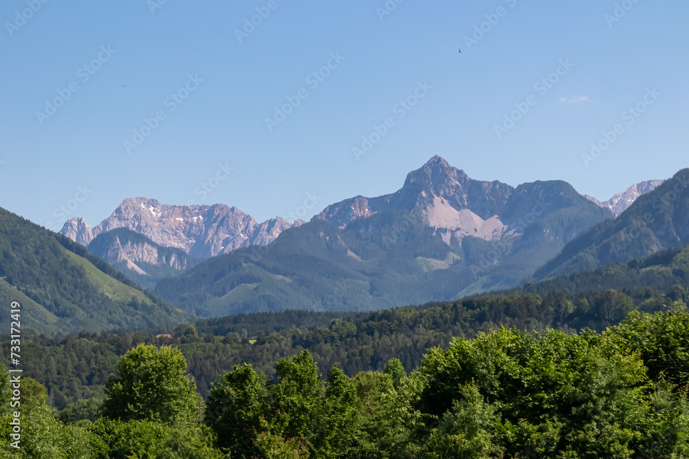 Obraz premium Scenic view of majestic mountain peaks of Karawanks seen from Feistritz im Rosental, Carinthia, Austria. Majestic Wertatscha and Kosiak summit in summer. Hiking in alpine wilderness Austrian Alps