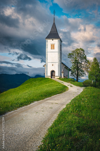Rural road and Saint Primoz church on the hill, Slovenia