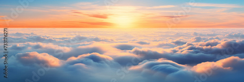 Aerial view of Beautiful sunrise sky above clouds or fog with dramatic light at dawn. © Wararat