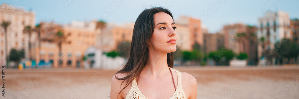 Beautiful brown-haired woman with long hair walks along the beach and looks around, Panorama. Gorgeous girl with long eyelashes Beautiful brown-haired woman with long hair walks along the beach and looks around, Panorama. Gorgeous girl with long eyelashes