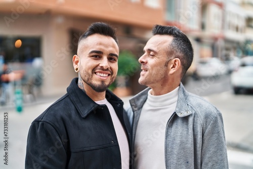 Two men couple smiling confident standing together at street