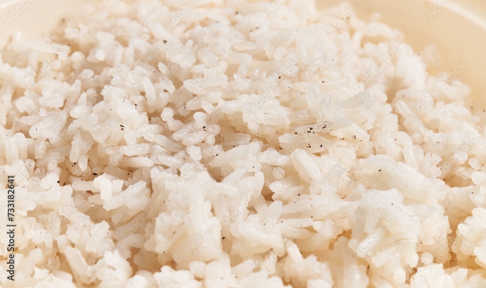 Close-up of cooked white rice grains on a plate, portraying a simple food texture. Close-up of cooked white rice grains on a plate, portraying a simple food texture.
