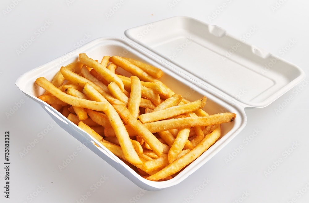Close-up of golden french fries in a white styrofoam container set against a clean background. Close-up of golden french fries in a white styrofoam container set against a clean background.