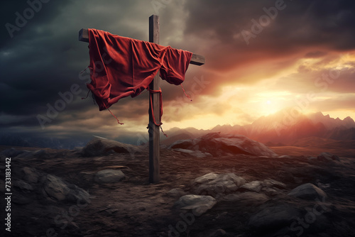 A christian cross with a red cloth, on top of the mountain against sunset light and cloudy sky in a dramatic scenery. Fosus on the crooss photo
