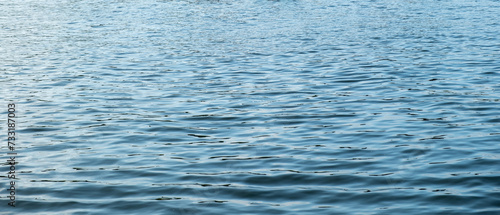 Rippled empty sea background texture. Wavy with reflection blue ocean water. Ad template, copy space