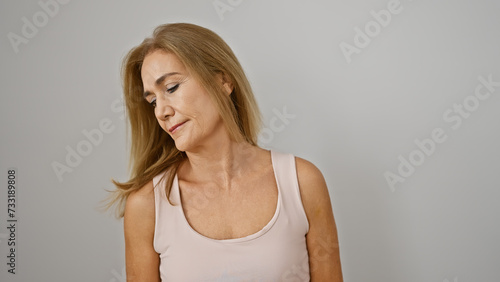 Contemplative mature blonde woman against a white background