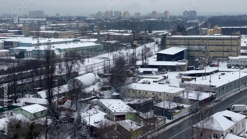 Industrial area in the city, train station, highway, and residential buildings. Dramatic winter day. Cityscape with old and new residential buildings next to the factory area.