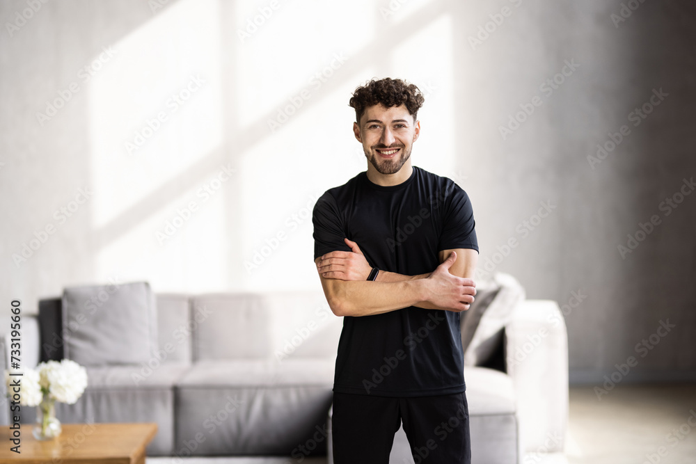 Athlete man trains hard at home or home standing in front of laptop.