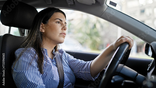 Young beautiful hispanic woman driving a car on the road © Krakenimages.com