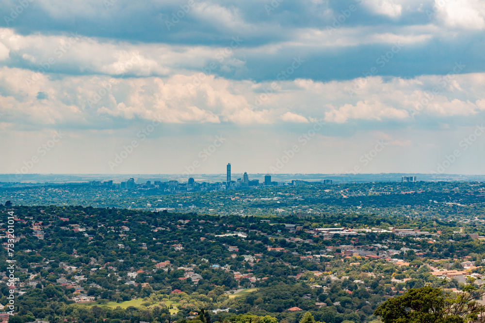 Fototapeta premium Elevated Panoramic view of Johannesburg - Northern View with Sandton centre of horizon from Northcliff with white soft clouds and clou