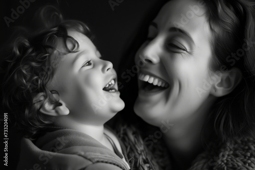 A heartfelt black and white photo of a laughing mother with her joyful child, sharing a moment of pure happiness.